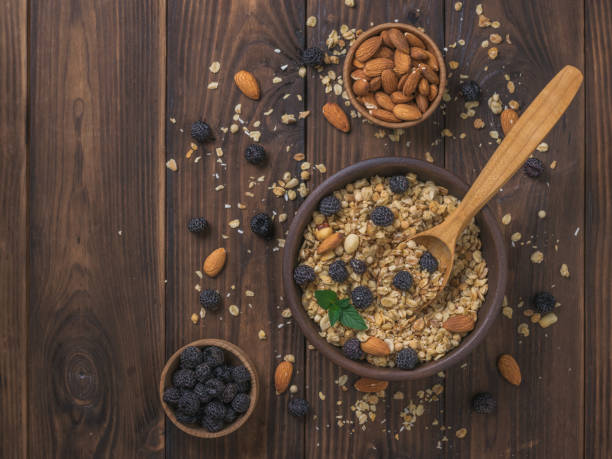 istock Granola with black raspberries and almonds on a wooden table. 1256553578