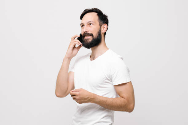 istock Portrait of happy young man smiling and using cellphone 1256553784
