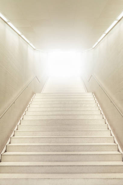 istock Up stairs going toward strong light. Stairs going up. White modern staircase. 1256554270