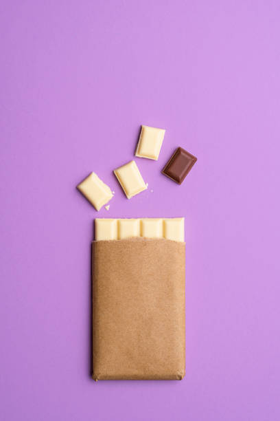 White chocolate bar in pieces. Milk chocolate square. Top view
