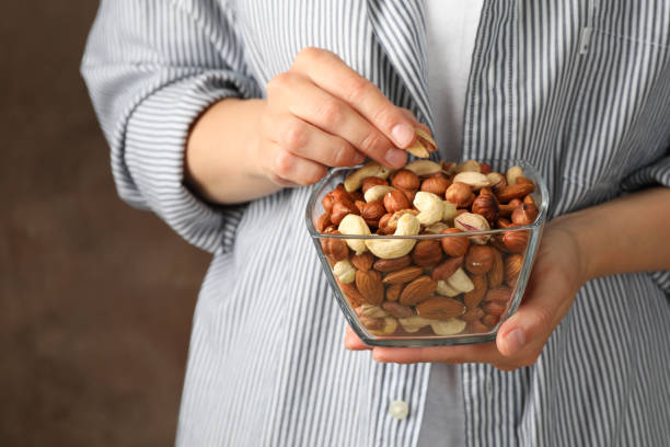 istock Woman hold bowl with different nuts. Healthy eating 1256555568
