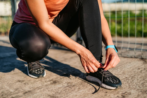 istock Female hands lacing running shoes 1256556918
