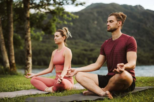 istock Younger couple practicing yoga outside 1256558392