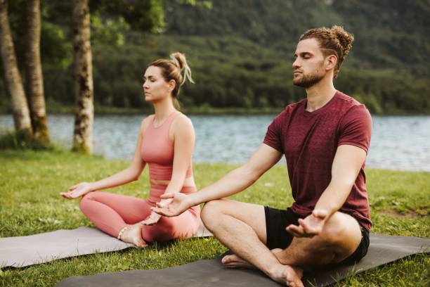 istock Couple doing yoga at the lake 1256558393