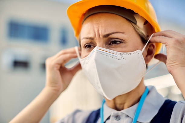 istock Female civil engineer putting on protective face mask during coronavirus epidemic. 1256558430