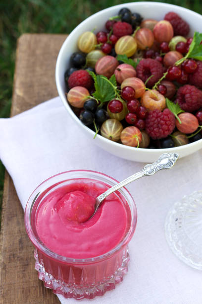 istock Red currant custard and a plate with berries on a stool in the garden. 1256558484
