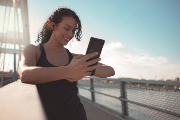 istock Fitness woman using smart phone 1256558837
