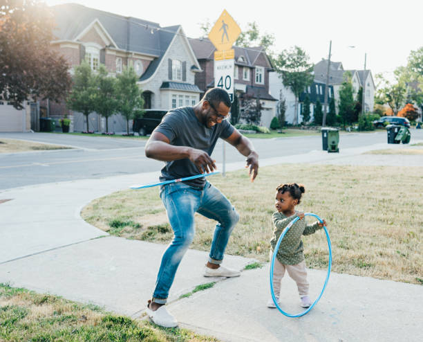 Hula hoop with dad the need for play that is based on human interaction african father stock pictures, royalty-free photos & images