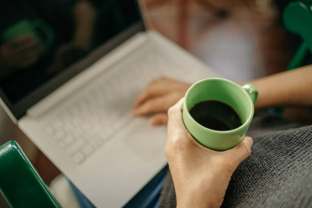 istock Woman using laptop and drinking coffee 1256559926