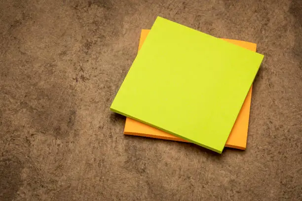 blank sticky note pads against handmade bark paper ready for a reminder text