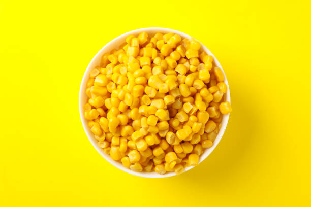 istock Bowl of fresh corn on yellow background, top view 1256561893
