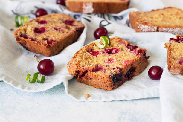 piezas de pastel de nuez con cereza sobre servilleta de lino, fondo de hormigón claro. panadería fresca casera para el desierto. - pound cake fruitcake cake loaf of bread fotografías e imágenes de stock