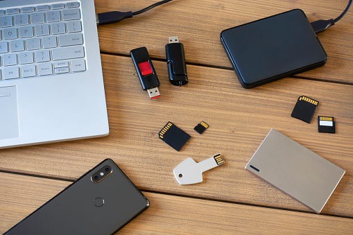 Varios dispositivos de almacenamiento de datos digitales. Memorias USB, disco duro externo, tarjetas SD, tarjetas mini y micro SD, computadora portátil y smartphone photo