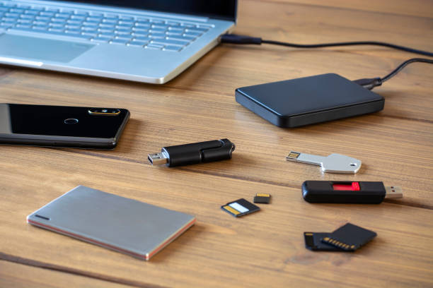 varios dispositivos de almacenamiento de datos digitales. memorias usb, disco duro externo, tarjetas sd, tarjetas mini y micro sd, computadora portátil y smartphone - office tool flash fotografías e imágenes de stock