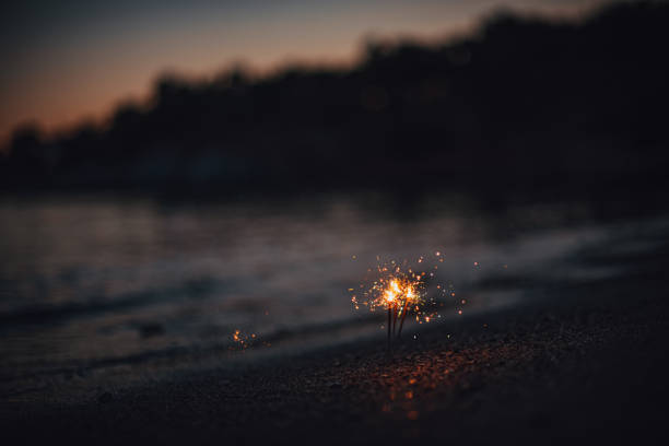 istock Burning Sparklers at Sunset on the Beach 1256562118
