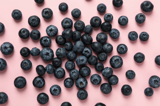 istock Delicious fresh blueberry on pink background, top view 1256564822