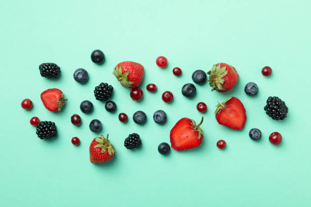 istock Mix of fresh berries on mint background, top view 1256565685
