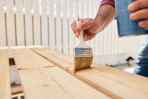 istock Carpenter using varnish on a finished wooden plank 1256567297
