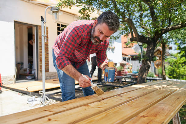 istock Maintenance carpenter lacquering wood with varnish 1256567497