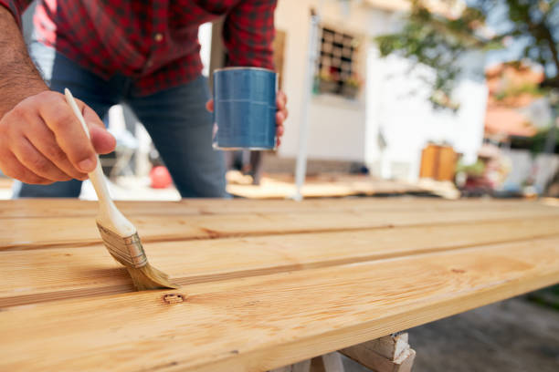 istock Carpenter using varnish on a finished wooden plank 1256568646