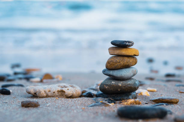 istock Pebbles are piled on a volcanic rock by the sea. Zen concept. Copy space 1256568716