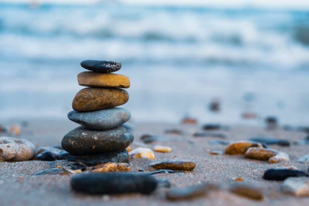 istock Pebbles are piled on a volcanic rock by the sea. Zen concept. Copy space 1256568724
