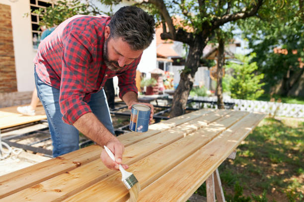 istock Skilled carpenter using varnish as a wooden finish 1256568784