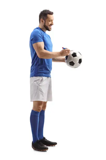 Photo of Athlete signing his autograph on a soccer ball