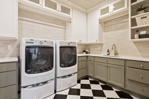 Black and white checked pattern on floor of laundry room of newly built home Olive green cabinets and shelves give way for lots of storage options utility room stock pictures, royalty-free photos & images