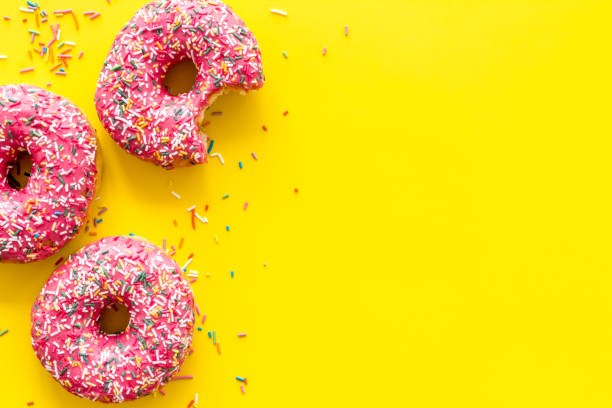 istock Pink berry donuts flat lay, top view. Glazed and sprinkles doughnuts 1256571719