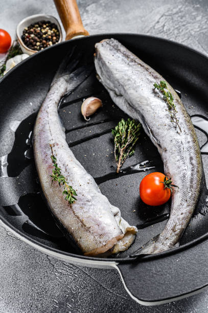istock Whole fish Pollock in a pan. Raw seafood. White background. Top view 1256572632