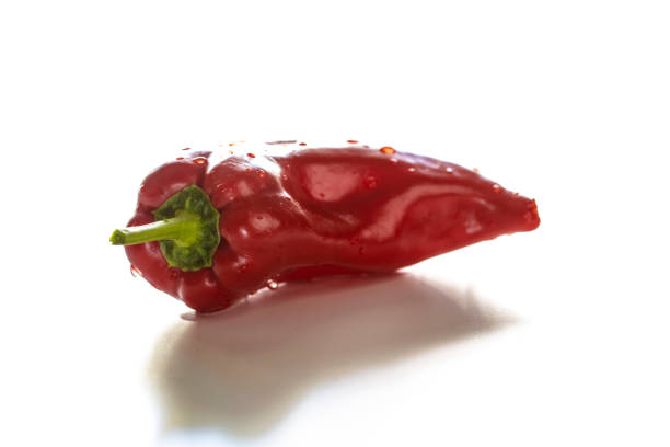 Fresh red pepper with water drops isolated on white background