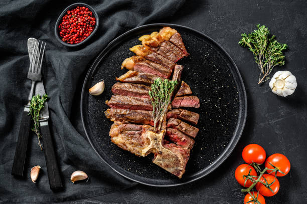 istock Sliced Grilled Florentine steak. T bone meat beef. Black background. Top view 1256574381