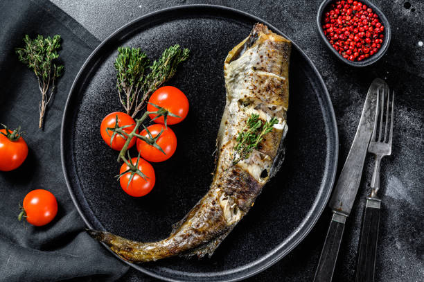 istock Baked pollock cooked in a savory marinade.  Black background. Top view 1256574551