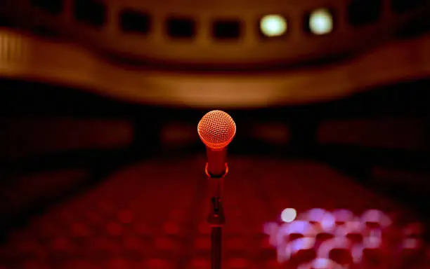 Photo of microphone in the center in front of an empty concert hall before the standup performance