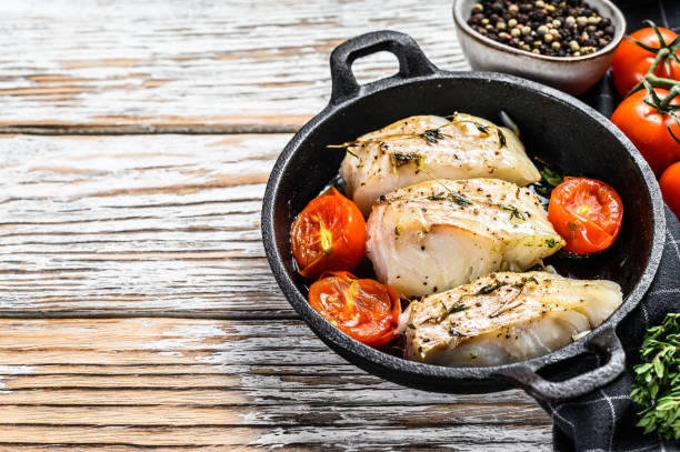 istock Grilled pollock or coalfish fillets in a pan. White background. Top view. Copy space 1256577527