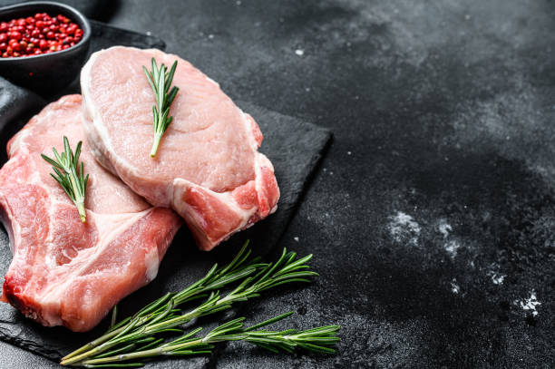istock Raw pork loin steak. Organic meat. Black background. Top view. Copy space. 1256577974