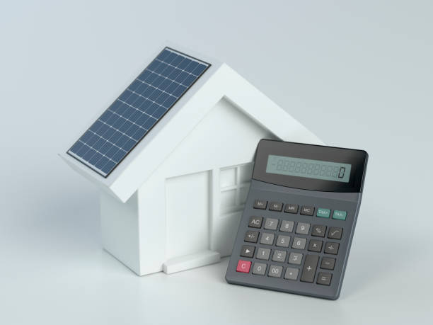 haus mit photovoltaik-solarpanel und taschenrechner auf weißem hintergrund - loan house calculator currency stock-fotos und bilder