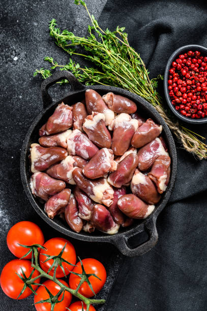 istock Fresh chicken hearts. Raw offal. Black background. Top view 1256579089