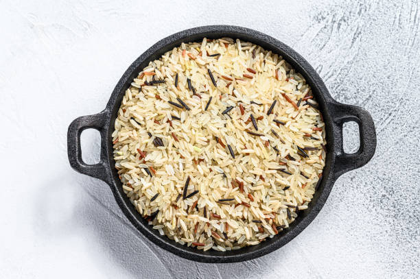 istock Mix rice in a cast-iron pan. White background. Top view 1256580214