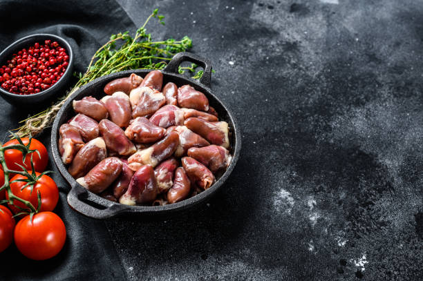 istock Fresh chicken hearts. Raw offal. Black background. Top view. Copy space 1256580553