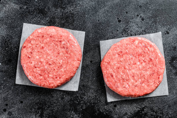istock Raw Burger patties, ground beef meat. Black background. Top view 1256582198