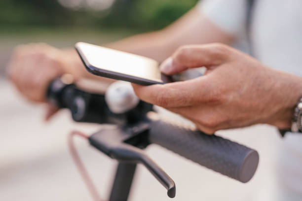 istock Crop man with electric scooter using smartphone 1256584964