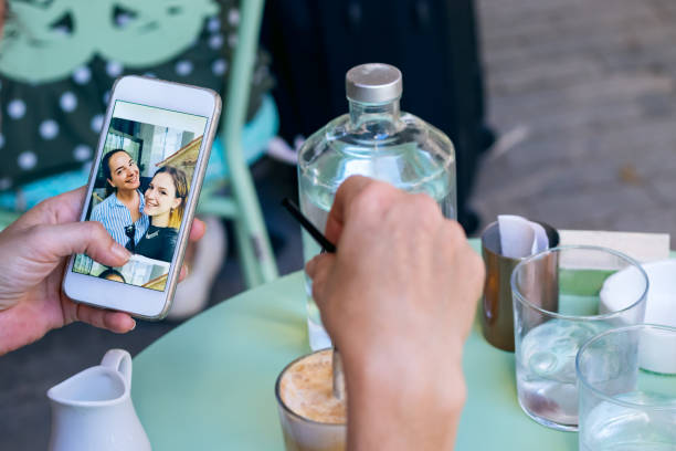 istock Female hand holding a mobile phone while having coffee looking photos. 1256589553