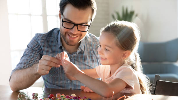istock Happy father and little daughter having fun with colorful beads 1256590476