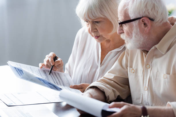istock Selective focus of elderly couple holding papers at table 1256595930
