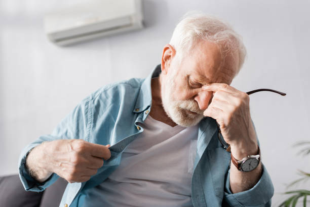 istock Tired elderly man feeling hot in living room 1256595946