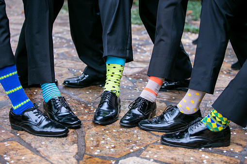 Groomsmen and groom exposing their socks for fun at a wedding reception
