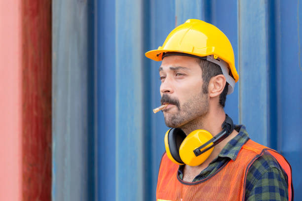 istock Factory worker with a cigarette smoke break, Labour takes a cigarette break 1256616887