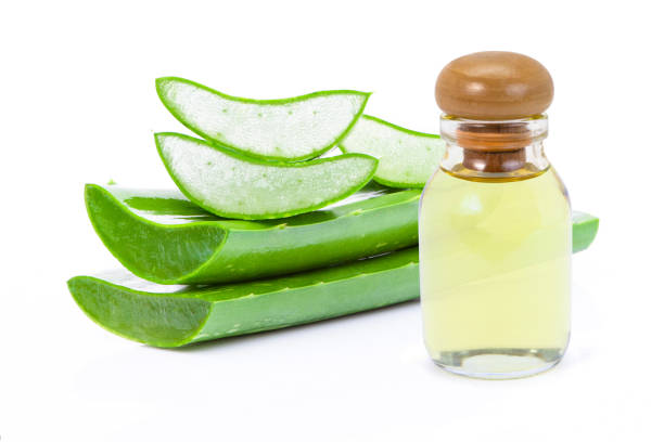 Aloe vera and essential oil Closeup bottle of aloe vera essential oil extract with aloevera leaf and cut slice isolated on white background. Skin care, health, beauty and spa concept. aloe juice stock pictures, royalty-free photos & images